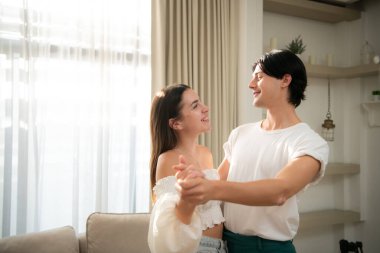 Sabahları evin oturma odasında genç bir çift birlikte mutlu bir şekilde dans ediyor.