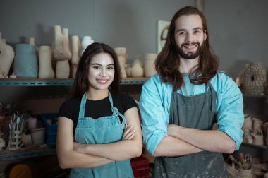 Genç bir iş adamı ve kadının portresi seramik bir iş yapıyor, çömlekçilik ve çömlekçilik işleriyle uğraşıyor.