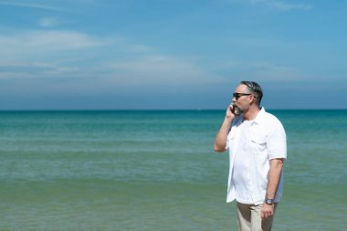 Yabancı turistler Asya 'nın güzel mavi deniz plajlarında geziniyorlar. Kumsalın ve denizin güzelliğini anlatan bir arkadaşımla telefonda konuşuyordum..