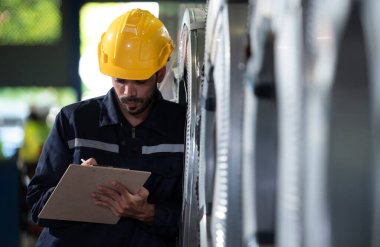Metal levha fabrikasının makinelerini incelemeye gelen büyük bir endüstrinin erkek mühendisinin portresi..