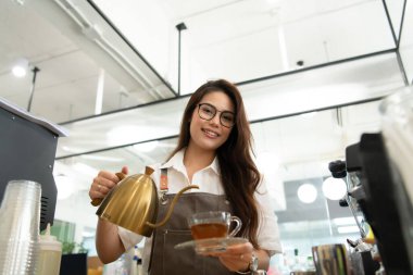 Dişi barista müşteriye çay yapmayı bitirdi, servis yapmaya hazır..