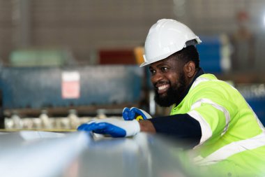 Genç mühendisler, metal levha döşemeleri üreten fabrikadaki makinelerin istenildiği gibi çalıştığını test ediyor ve doğruluyor.