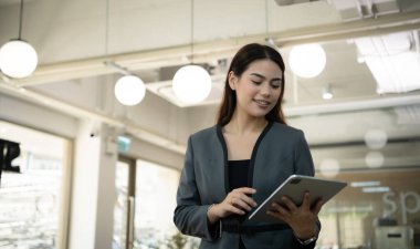 Portrait of Business female rookie in the new entrepreneurial with a tablet as a tool to help in the work clipart