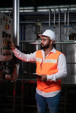 Makine Mühendisi Bir sonraki döngüye başlamadan önce hazır olup olmadığını kontrol etmek için makinenin elektronik devresini kontrol ediyor
