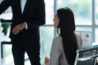 Bir grup genç Asyalı girişimci. Doğal ışık pencereli bir toplantı odasında hisse senedi yatırım verilerini gözden geçirmek için toplantı.