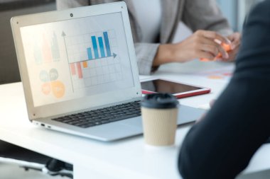 Bir grup genç Asyalı girişimci. Top Management, ekipten gelen yatırım verilerini gözden geçirmek için doğal ışık pencereli bir toplantı odasında toplanıyor..