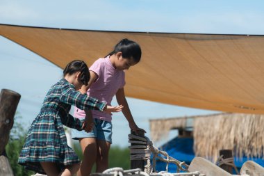 Çocuklar ip cambazlığında oynarken eğleniyor. açık bir gün, güzel bir gökyüzü