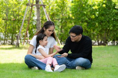 Baba, anne ve kız Asyalı aile evin bahçesinde mutlu mesut eğleniyor.