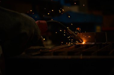 Bir kaynakçı metali kaynak yapmaya çalışıyor. belirlenen biçime göre kalite çalışması yaratmak için