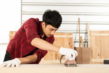 Asyalı genç marangoz müşteriler için titizlikle çalışıyor. Genç bir adam, başarılı bir girişimci ve çok yetenekli..