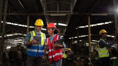 Yabancı mühendis eski makine fabrikasını teftiş etmeye geldi. Afrikalı bir kadın tamirci, eski makinelerin onarımının detaylarını ve ilerleme raporlarını açıklıyor..