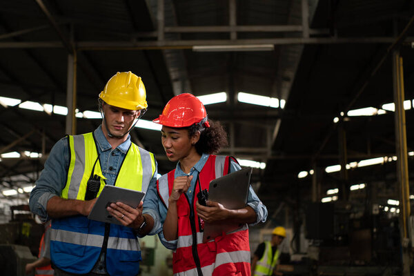 The foreign chief engineer came to inspect the old mechanical factory. There is an African female mechanic explaining details and progress reports on old machines being repaired to restore normal operation.