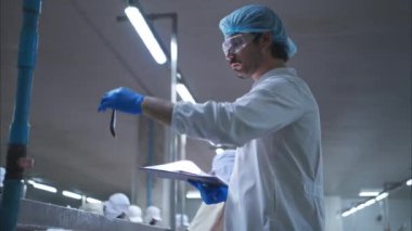 Hammadde kalitesi müfettişleri balık parçalarını konserve balık üretim sürecine girmeden önce değerlendirir ve inceler.
