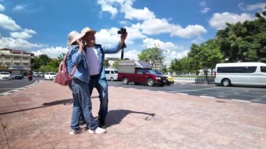 Tayland 'ın eski Bangkok şehrinde yaşlı bir çift caddede yürüyor.