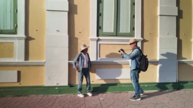 Tayland 'ın eski Bangkok şehrinde yaşlı bir çift caddede yürüyor.