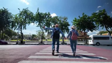 Tayland 'ın eski Bangkok şehrinde yaşlı bir çift caddede yürüyor.