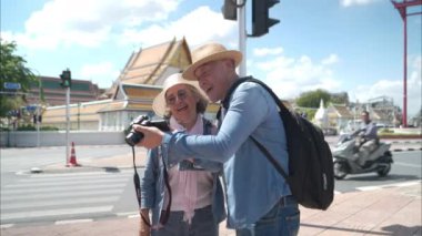 Tayland 'ın eski Bangkok şehrinde yaşlı bir çift caddede yürüyor.