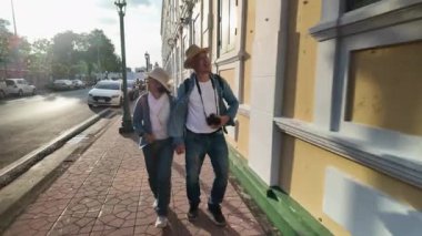 Tayland 'ın eski Bangkok şehrinde yaşlı bir çift caddede yürüyor.