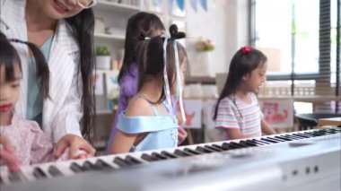 Bir grup çocuk sınıfta şarkı söyleyip dans ediyor.