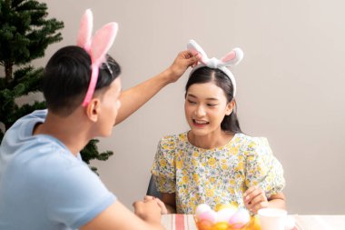 Genç bir çift Paskalya yumurtalarını tasarlıyor ve boyuyor.