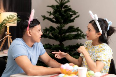 Genç bir çift Paskalya yumurtalarını tasarlıyor ve boyuyor.