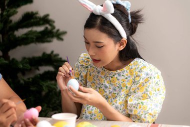 Genç bir çift Paskalya yumurtalarını tasarlıyor ve boyuyor.