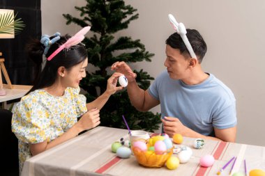 Genç bir çift Paskalya yumurtalarını tasarlıyor ve boyuyor.