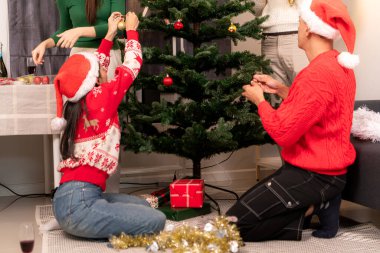 Bir grup arkadaş Noel 'i kutlamak için içki içip Noel ağacı süslüyorlar.