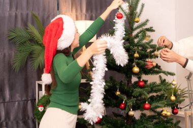 Bir grup arkadaş Noel 'i kutlamak için içki içip Noel ağacı süslüyorlar.