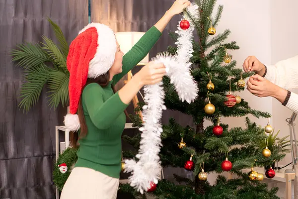 Bir grup arkadaş Noel 'i kutlamak için içki içip Noel ağacı süslüyorlar.