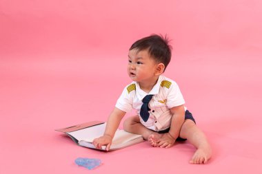 Pembe arka planda pilot kıyafetli çocuk portresi