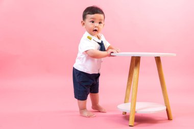 Pembe arka planda pilot kıyafetli çocuk portresi