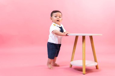 Pembe arka planda pilot kıyafetli çocuk portresi