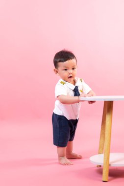 Pembe arka planda pilot kıyafetli çocuk portresi