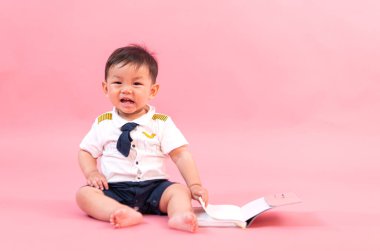 Pembe arka planda pilot kıyafetli çocuk portresi