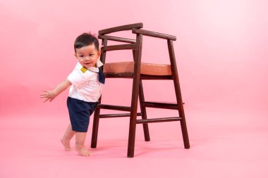 Pembe arka planda pilot kıyafetli çocuk portresi