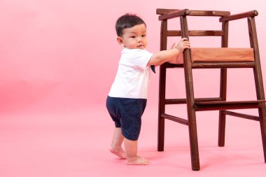 Pembe arka planda pilot kıyafetli çocuk portresi