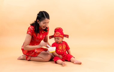 Çin Yeni Yılı giysileriyle anne ve oğlunun portresi.