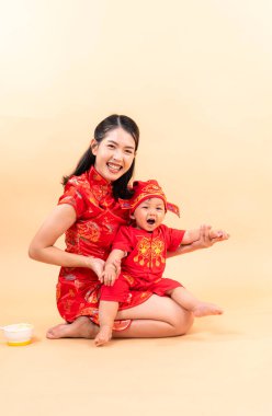 Çin Yeni Yılı giysileriyle anne ve oğlunun portresi.