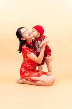 Çin Yeni Yılı giysileriyle anne ve oğlunun portresi.