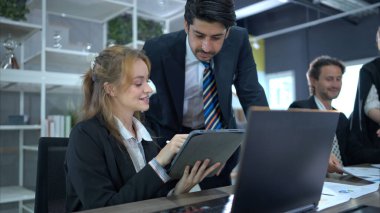 Konferans salonunda, bir grup işadamı takip toplantısını ve operasyonların sonuçlarını tartışıyor.