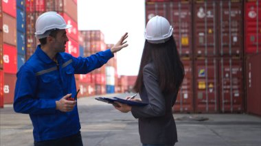Konteynır imalat müdürü ve iş kadınları konteyner deposuna giren çıkan malları planlamak ve taşımak için bölgeyi araştırıyorlar.