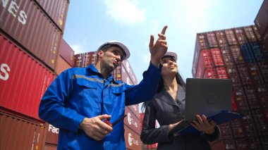 Konteynır imalat müdürü ve iş kadınları konteyner deposuna giren çıkan malları planlamak ve taşımak için bölgeyi araştırıyorlar.