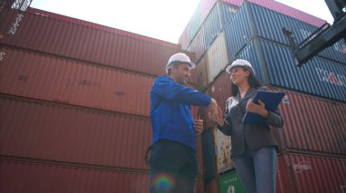 Konteynır imalat müdürü ve iş kadınları konteyner deposuna giren çıkan malları planlamak ve taşımak için bölgeyi araştırıyorlar.