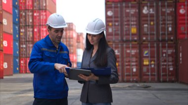 Konteynır imalat müdürü ve iş kadınları konteyner deposuna giren çıkan malları planlamak ve taşımak için bölgeyi araştırıyorlar.