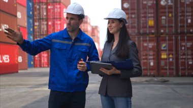 Konteynır imalat müdürü ve iş kadınları konteyner deposuna giren çıkan malları planlamak ve taşımak için bölgeyi araştırıyorlar.