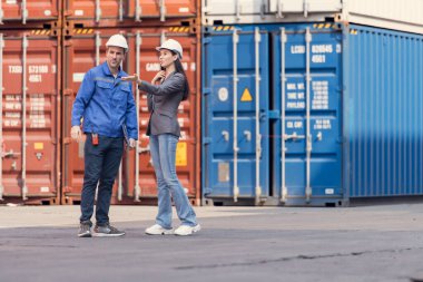 Konteynır imalat müdürü ve iş kadınları konteyner deposuna giren çıkan malları planlamak ve taşımak için bölgeyi araştırıyorlar.