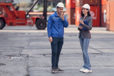 Konteynır imalat müdürü ve iş kadınları konteyner deposuna giren çıkan malları planlamak ve taşımak için bölgeyi araştırıyorlar.