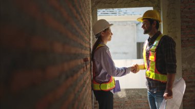 Mimarlar ve mühendisler, konut inşaatının ilerlemesini değerlendirmek için birlikte çalışırlar.