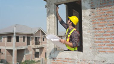 Mühendislerin portresi konut inşaatının ilerlemesini inceler ve değerlendirir.